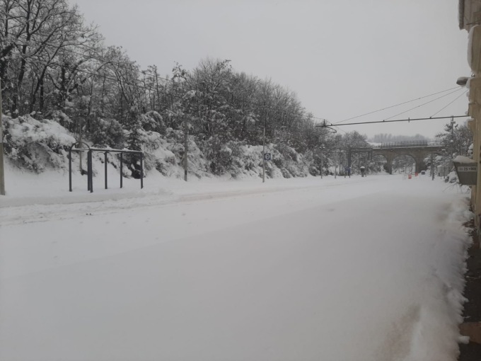 Continuano i disagi a causa della neve: passeggeri camminano nella neve per raggiungere la stazione